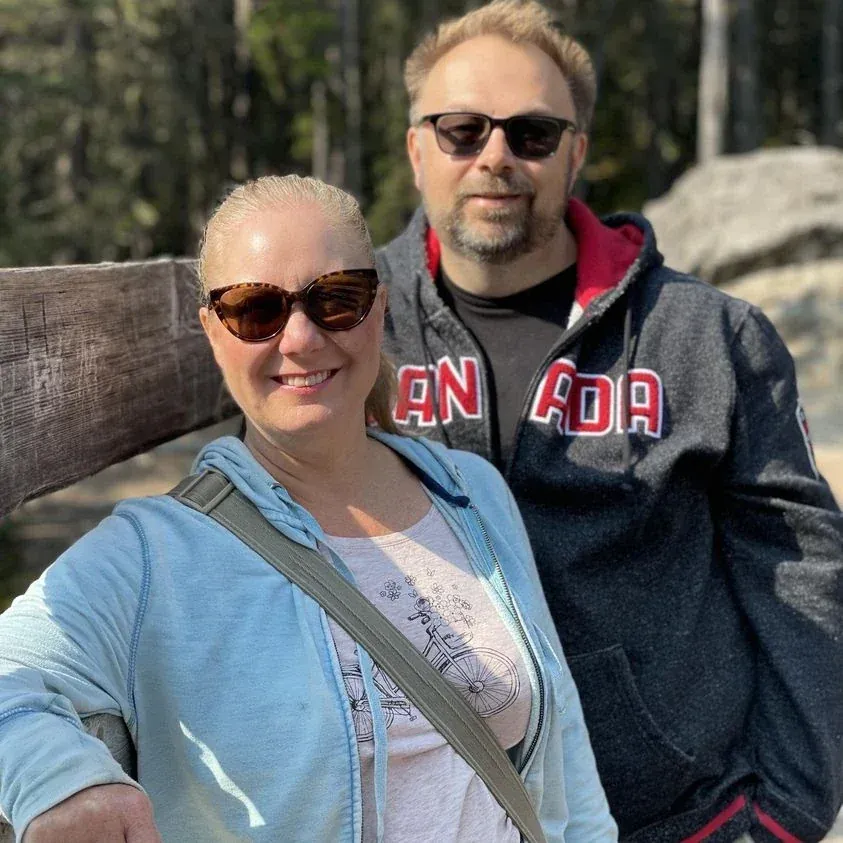 Smiling man and woman embracing outdoors on a sunny day